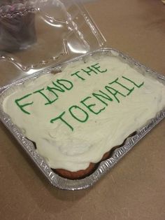 a cake with frosting that says find the toenail on it and green writing