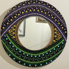 a colorful circular mirror hanging on the wall