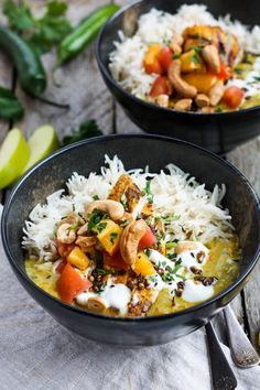 two black bowls filled with rice and vegetables