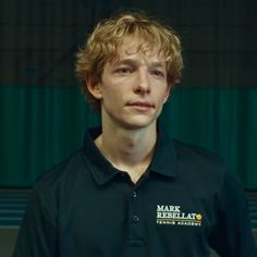 a young man wearing a black polo shirt