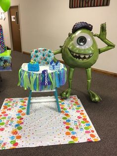 an inflatable green monster standing next to a baby's crib on the floor