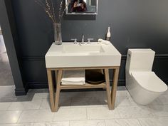 a bathroom with a toilet, sink and mirror in it's centerpieces