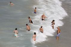 many people are in the water at the beach