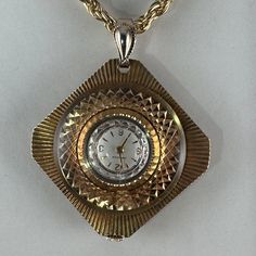 Vintage Bulova Carrvelle Pendant Watch 1 3/8 Inch Tall Octagon Shape Round Face On Round Bezel With Beautiful Brocading Pattern On Front And Reverse Mechanical Hand Wind Swiss Movement Gold Plated 3mm Rope 24 Inch Necklace Watch Has Been Serviced And Cleaned Keeps Time Pendant Watch, Mechanical Hand, Octagon Shape, Pendant Watches, Watch Necklace, Round Face, Womens Jewelry Necklace, Vintage Jewelry, Gold Plate