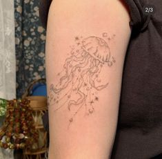 a woman's arm with a tattoo on it that looks like a jellyfish