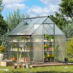 a small greenhouse in the middle of a field with flowers and plants growing inside it