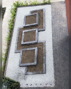 an aerial view of a garden area with gravel and concrete blocks in the shape of rectangles