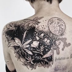 the back of a man's shoulder with tattoos on it