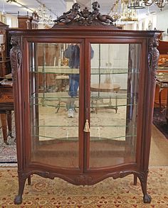 an antique china cabinet with glass doors in a store