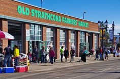 an old fashioned farmers market with people walking by