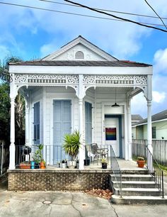 a white house with blue shutters on the front door and steps leading up to it