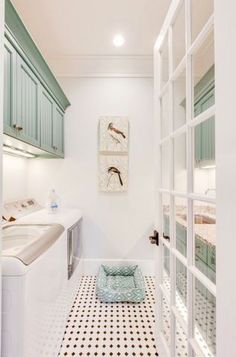 a long narrow bathroom with green cabinets and tile flooring, along with a white sink