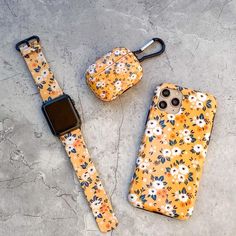 an orange flowered phone case and matching watch strap are sitting on the ground next to each other