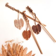 four wooden spoons, two with heart shaped leaves and one with feathered hearts hanging from them