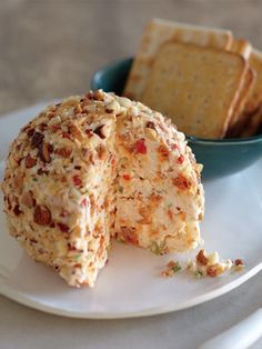 a plate with crackers and cheese on it next to a bowl of crackers