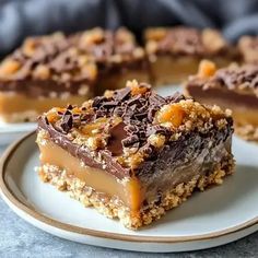 two plates with pieces of chocolate caramel slice dessert on top of each other and one piece cut in half