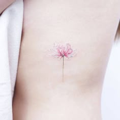 a woman's stomach with a pink flower tattoo on her left side ribcage