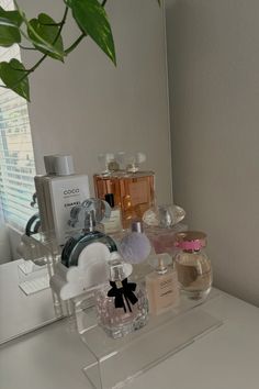 a white counter topped with lots of different types of perfumes and bottles on top of it