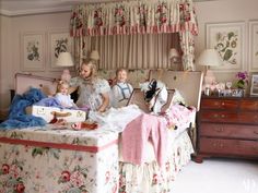 a group of people sitting on top of a bed in a room with floral bedspreads