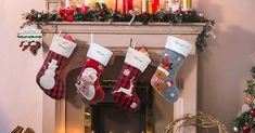 christmas stockings hanging from a mantel with candles and decorations around them on the mantle