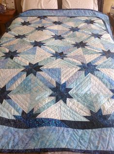 a bed with a blue and white quilt on it