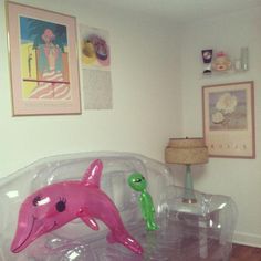 two plastic toys in the shape of dolphins on top of a couch with a lamp next to it