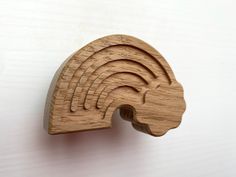 a wooden brooch with a rainbow design on the front and back of it's head