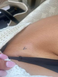 a close up of a person's stomach with a small triangle tattoo on it