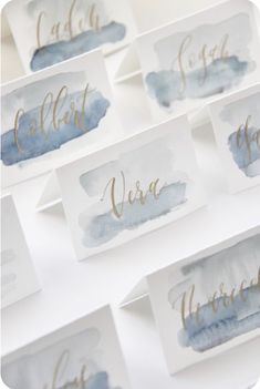 watercolor place cards with gold lettering on them