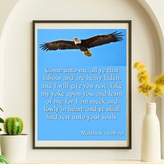 an eagle flying in the sky with a bible verse below it on a shelf next to potted plants