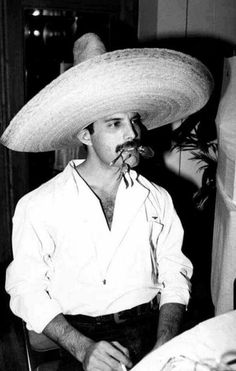 a man wearing a sombrero sitting in a chair