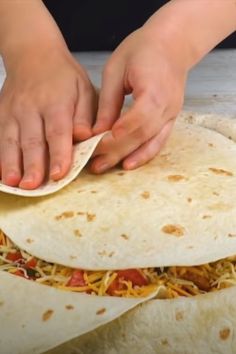 a person is making tortillas with cheese and sauce