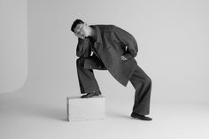 a man in a suit leaning on a box