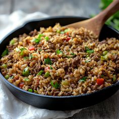 a skillet filled with rice, meat and vegetables