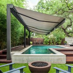 an outdoor swimming pool surrounded by wooden steps and benches under a canopy over the water