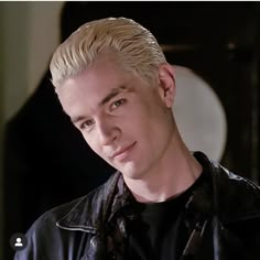 a man with blonde hair wearing a black leather jacket