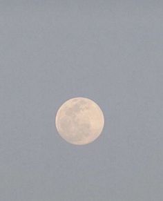 an airplane flying in the sky with a full moon behind it's back end