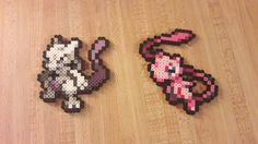 two pixel art pieces sitting on top of a wooden floor