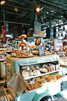 an old fashioned ice cream truck is filled with pastries and breads at the market