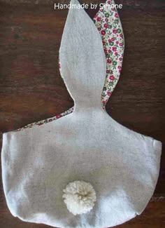 a white bag with flowers on it sitting on top of a wooden table