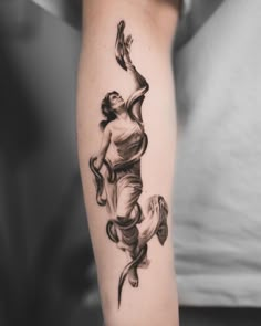 a black and white photo of a woman's arm with a tattoo on it