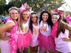 a group of girls dressed in pink posing for the camera