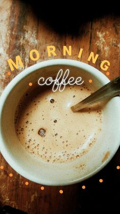 a cup of coffee with a spoon in it on top of a wooden table that says morning coffee