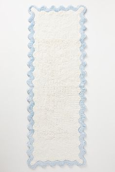 a white and blue rug with scalloped edges