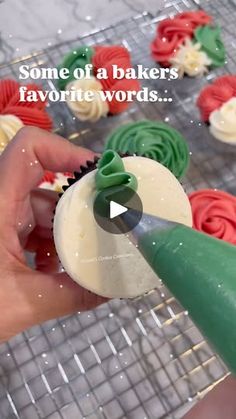 someone is decorating cupcakes with green and red icing on a wire rack