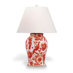 a red and white vase lamp with a white shade on it's base, sitting against a white background