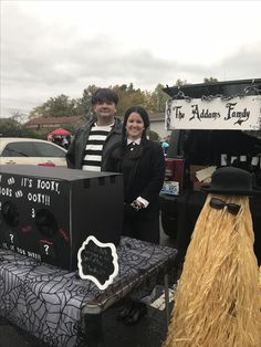 two people standing in front of a booth at an outdoor event with fake grass on the ground