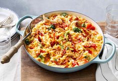 a large casserole dish with broccoli, tomatoes and other toppings