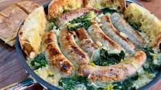 sausages and greens in a skillet with bread on the side, ready to be eaten