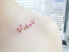 small pink flowers on the back of a woman's shoulder